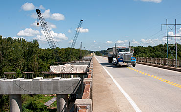 image of a semi driving across a bridge which is under construction