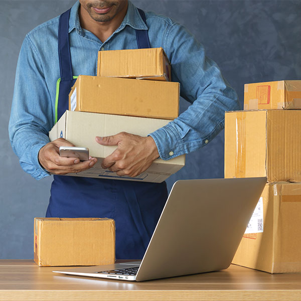 Guy holding boxes and boxes stacked on table