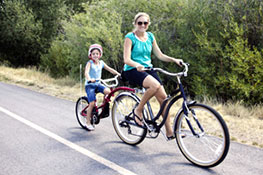 mother and daughter biking along side of road
